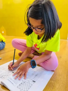 Young child solving chess puzzles to improve strategic thinking skills in GKS Chess Academy