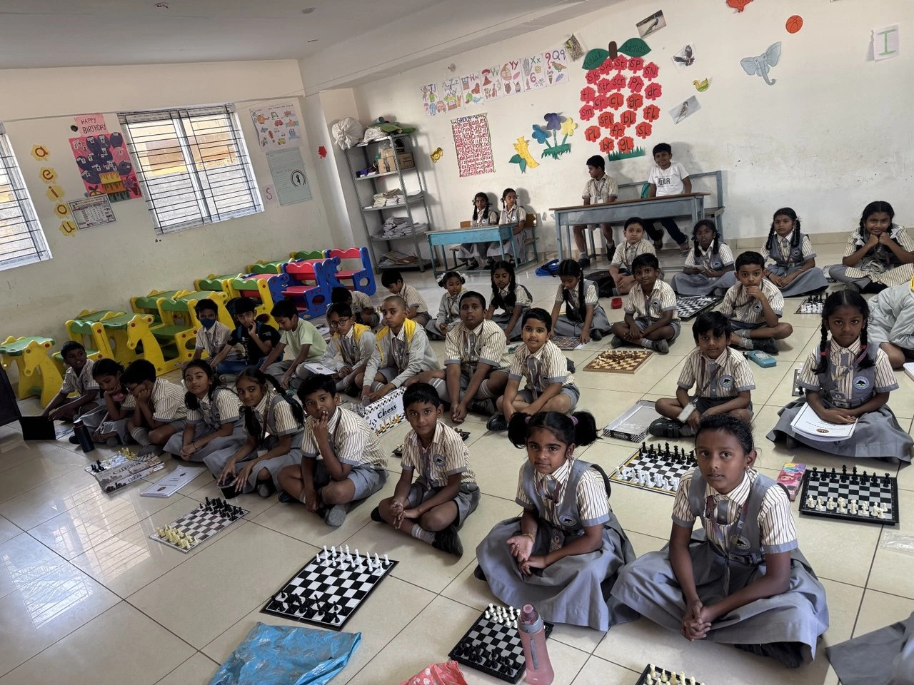 Group of school children learning chess in a classroom setting