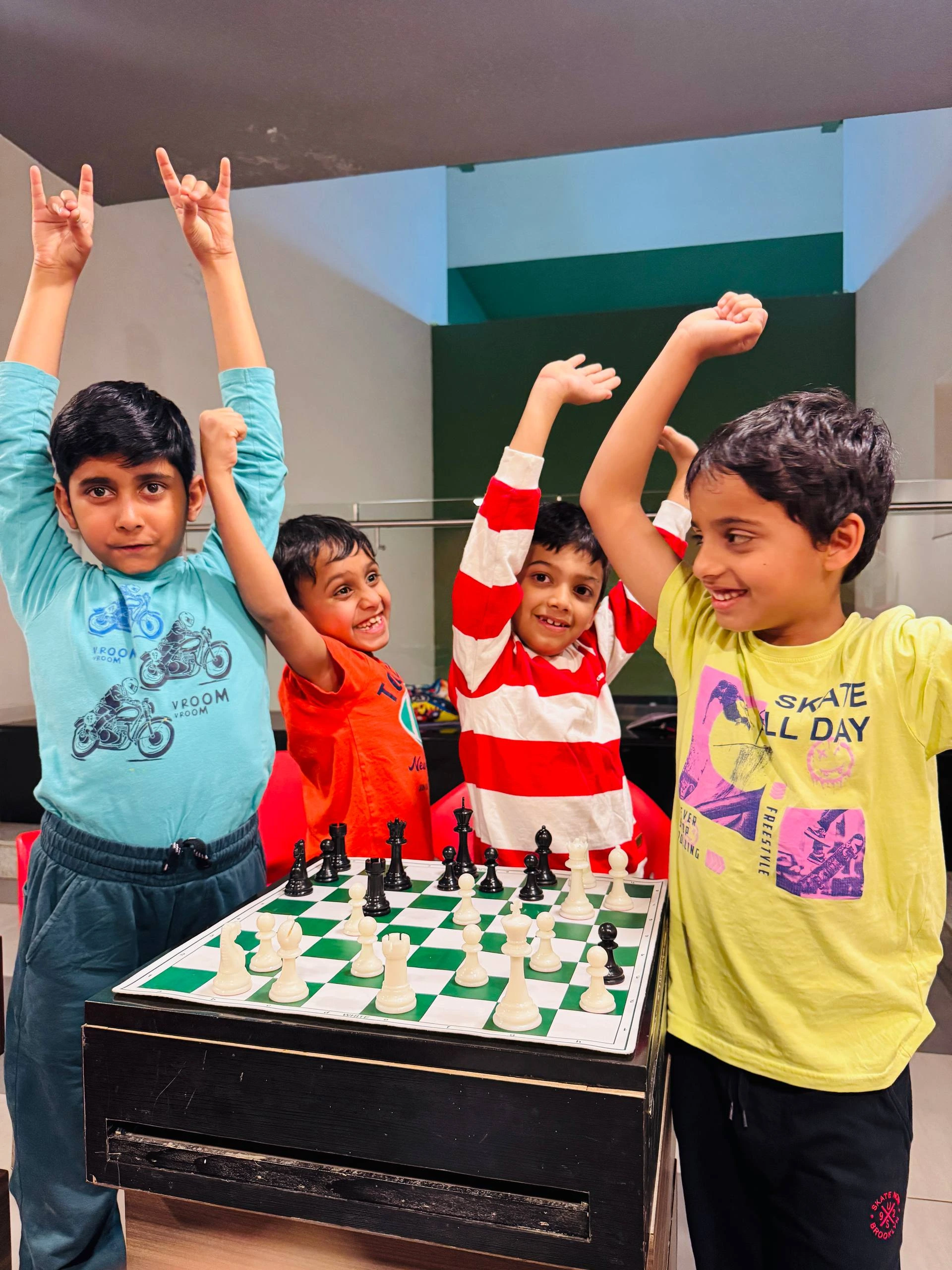 Group of kids celebrating chess victory with trophies at GKS Academy