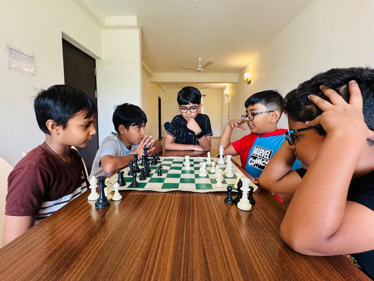 Children focused on chessboard during strategic lesson