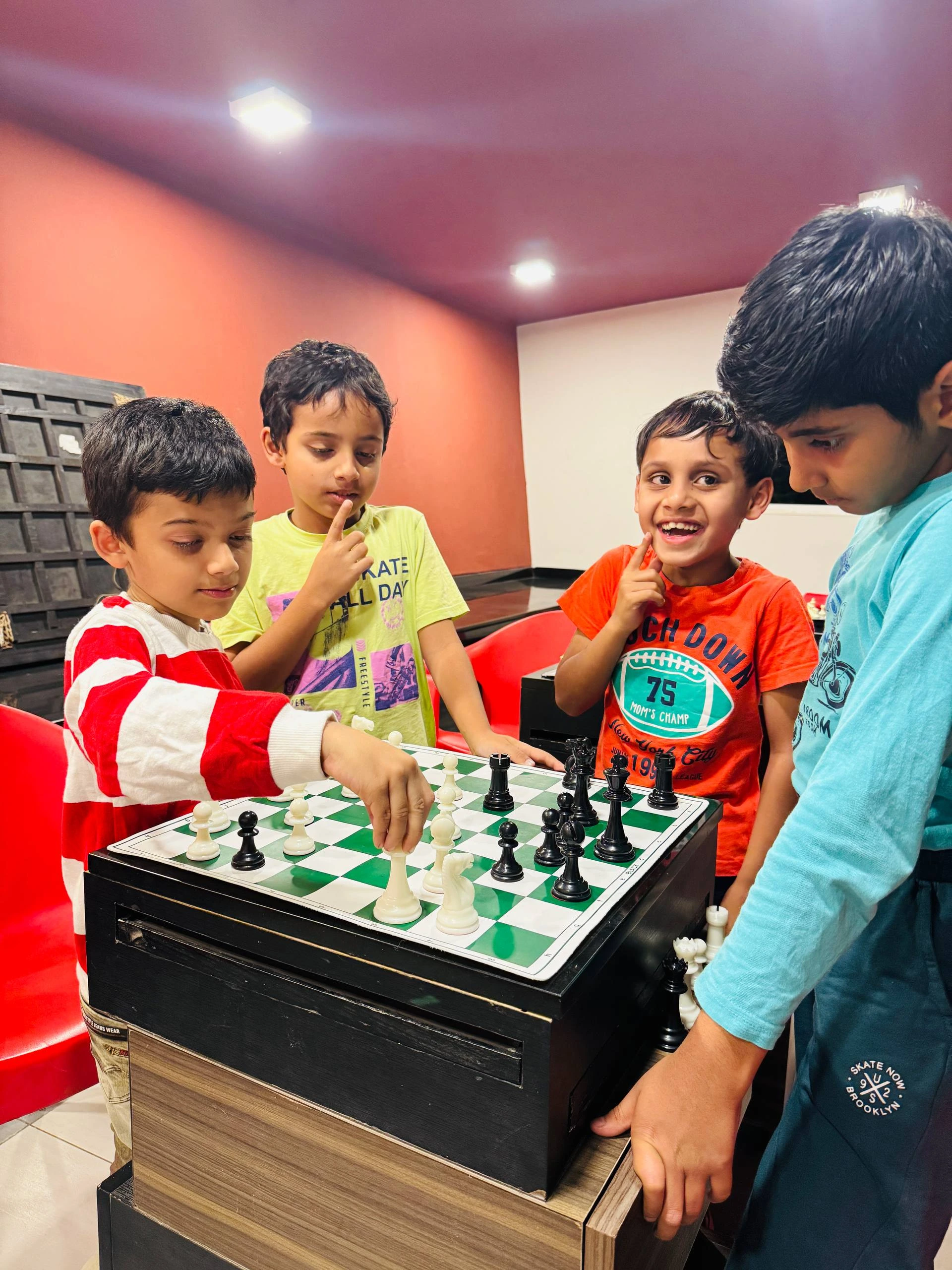 Children engaged in hands-on chess learning using boards